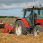 Red tractor at work in the field.