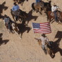 In this April 12, 2014, file photo, the Bundy family and their supporters fly the American flag as their cattle is released by the Bureau of Land Management back onto public land outside of Bunkerville, Nev.