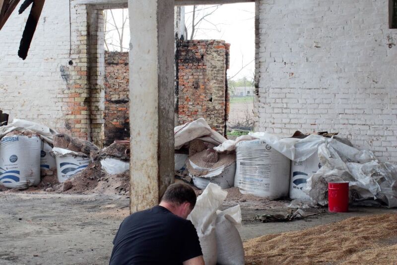 Farmer examines damaged barn