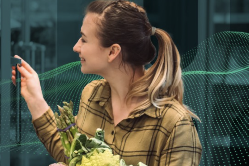 young white woman shopping holding romanesco cauliflower broccoli and asparagus