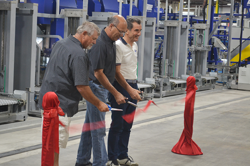 Scott Halliday (from left), Diamond Fruit Growers chairman, David Garcia, Diamond president, and Angelo Benedetti, CEO of Unitec, cut the ribbon July 16 at the unveiling of a special pear packing line at the Diamond Fruit packing facility in Hood River, Ore.