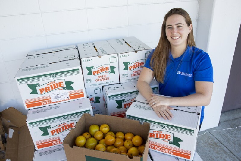  Christa Court, an economist with the University of Florida Institute of Food and Agricultural Sciences, poses with freshly harvested oranges at a student citrus sale event on the UF main campus in Gainesville -- Friday, Dec. 7, 2018. Court is part of a team that produced a new report on the economic contributions of Florida's citrus industry in the 2016-17 growing season. Total economic contributions, including multiplier effects, include $7.241 billion in industry output (sales revenue) and more than 50,000 jobs