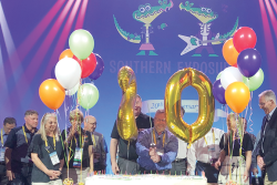 David Sherrod (center), president and CEO of the Southeast Produce Council, cuts a cake with a sword at last year’s Southern Exposure to celebrate the 20th anniversary of the show.