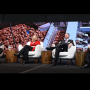 Four people sit in white chairs on a stage, with potatoes arranged decoratively in the background.