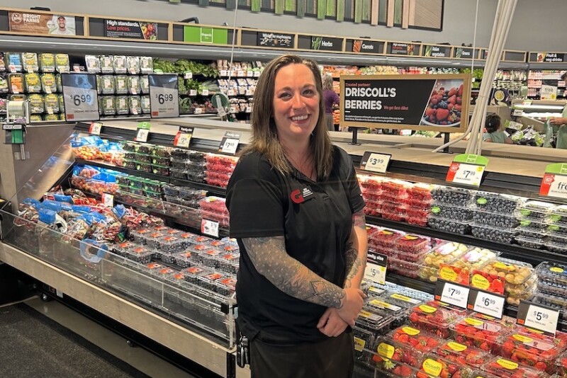woman in front of berries at supermarket