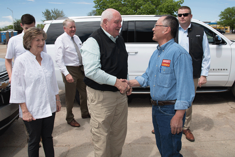 Agriculture Sonny Perdue (center) greets Robert Sakata of Sakata Farms in May in Brighton, Colo., during one of his numerous visits to fruit and vegetable operations.
