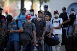 Migrants seeking a U.S. work visa are pictured as they waiting to take a bus that will take to their hotel in Monterrey, Mexico March 24, 2020.  REUTERS/Daniel Becerril