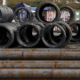 A worker stands near steel coils and steel rods at a steel collection facility in Tokyo, Japan.