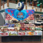 Grocery store display with potatoes in the back and other items in the front.
