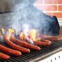 WSU Meat Scientist Blake Foraker grills a batch of sausage made with pork from gene-edited pigs for a cookout celebrating Professor Jon Oatley's research team on the WSU Pullman campus.