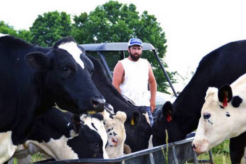In this photo taken May 17, 2017, Ben Seaton, 21, stands on his family's dairy farm in Debusk, Tenn. Seaton takes pride in the cows he has bred and now milks each day on the farm.