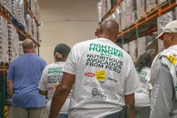 people with Fight Hunger t shirts in a warehouse