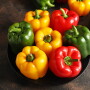Green, red and yellow bell peppers in a bowl