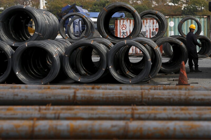 A worker stands near steel coils and steel rods at a steel collection facility in Tokyo, Japan.