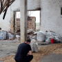 Farmer examines damaged barn