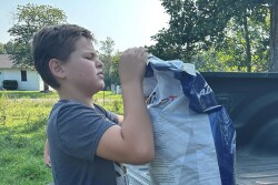 Farm Kid with feed bag on farm looking stressed