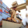 Yellow cargo ship docked at a port, holding white containers with the Dole company logo.