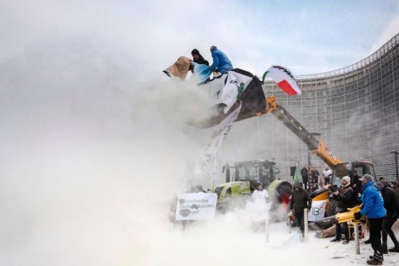 European dairy farmers spray the EU Council building with milk powder to protest the crisis in their sector, in Brussels on Monday, Jan. 23, 2017.
