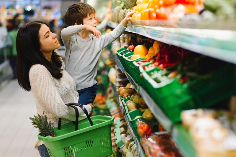 Woman grocery shopping with a child