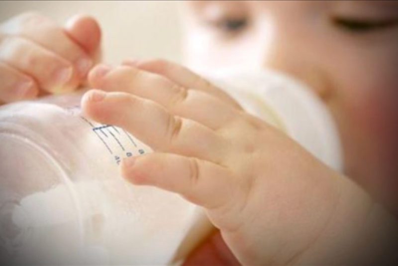 Child drinks from baby bottle