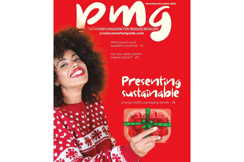 black woman in winter sweater holding tomato clamshell