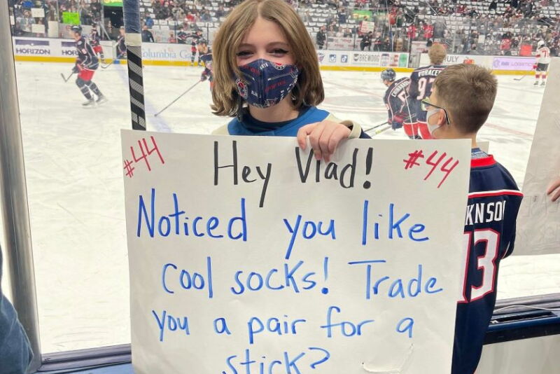 Jacey Snyder holding sign at Blue Jackets hockey game