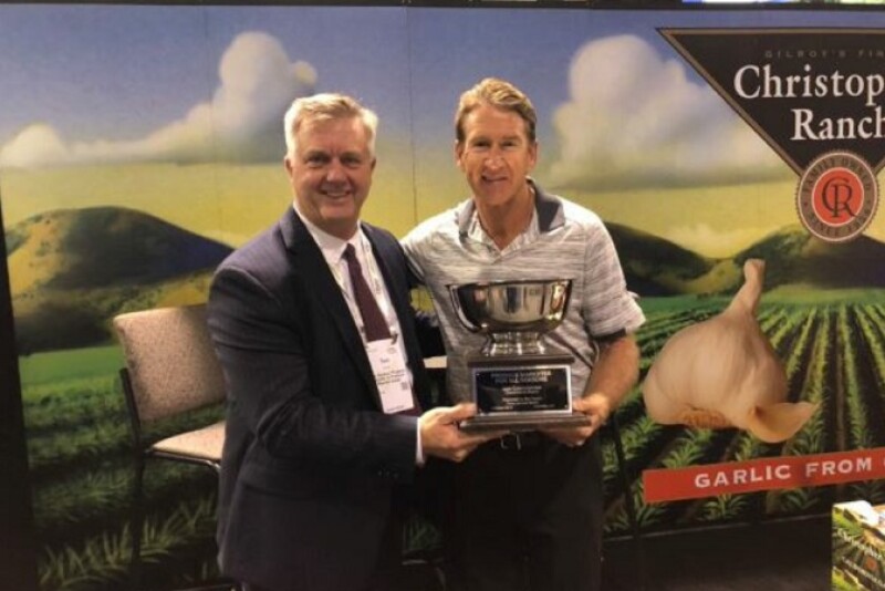 The Packer's Tom Karst (left) presents the 2019 Produce Marketer for All Seasons award to Bill Christopher of Christopher Ranch, who accepted the award on behalf of his father Don Christopher. 