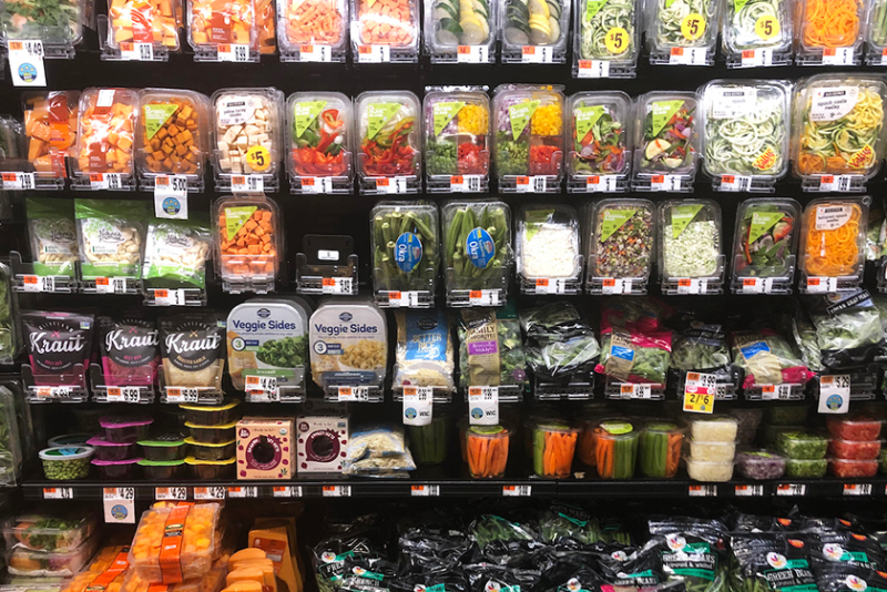 An assortment of pre-cut and packaged produce on a store's produce shelves