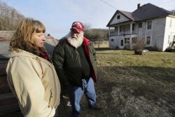 Julie and Phil Henneman, who lost their son Keith to suicide in 2006, when he was 29, talk about the experience outside the old farmhouse in Boscobel, Wis. The Hennemans continue to live on the 215-acre farm with two other sons, but they aren't farming. 