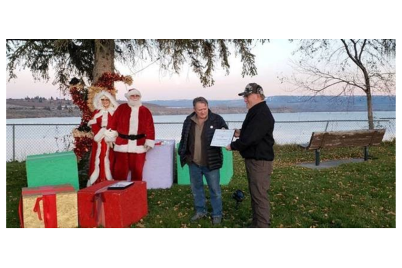 Mike Mauk, president of the Brewster, Wash., Chamber of Commerce, gives Steve Stewart (far right), assistant general manager of Honeybear Growers, a certificate in recognition of the company's contributions to the community.
