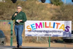 A man speaks with a festival banner in the background. Photo: Courtesy Wholesum